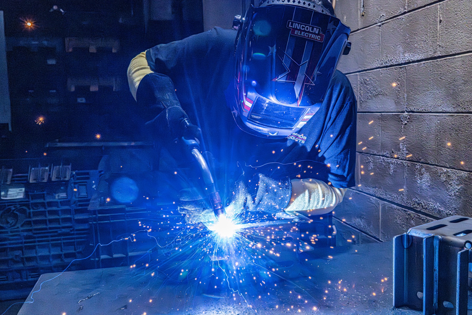 Welder assembling a metal component with sparks