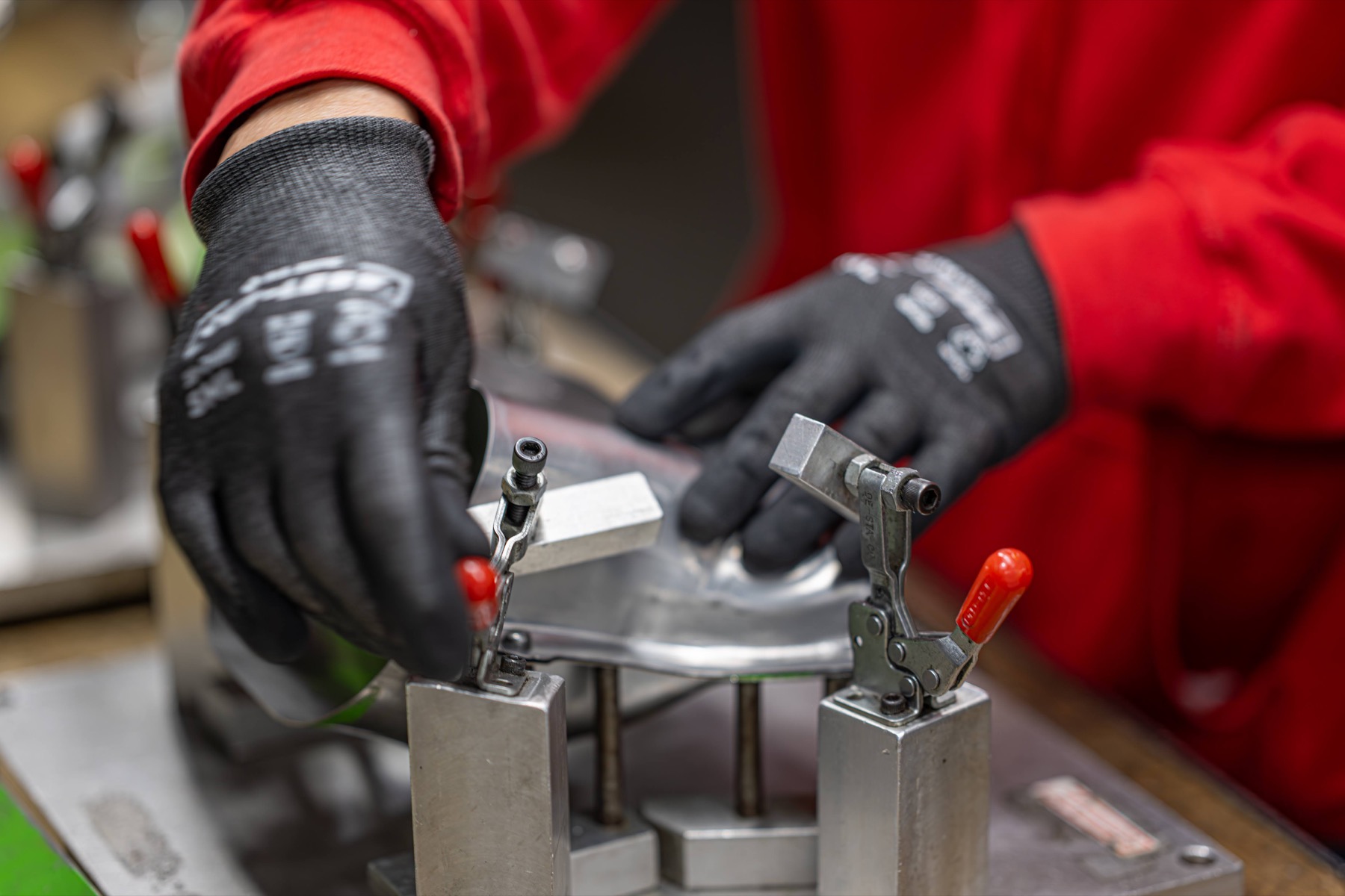 Gloved operator positioning a formed exhaust part in a fixture